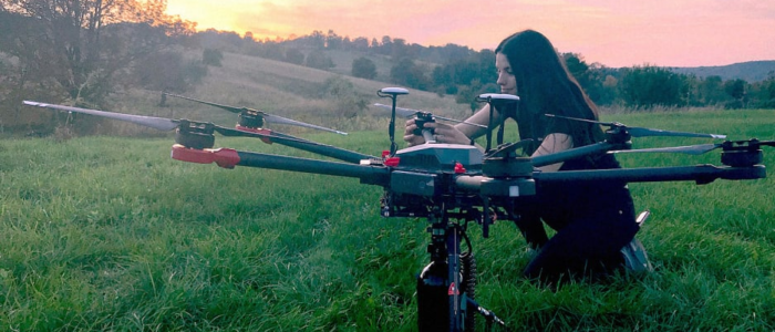 Woman in field with one of Flash Forest’s prototype drones
